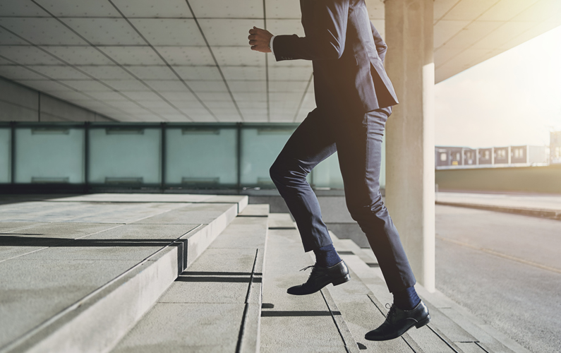 man running up stairs, symbolizing upward motion